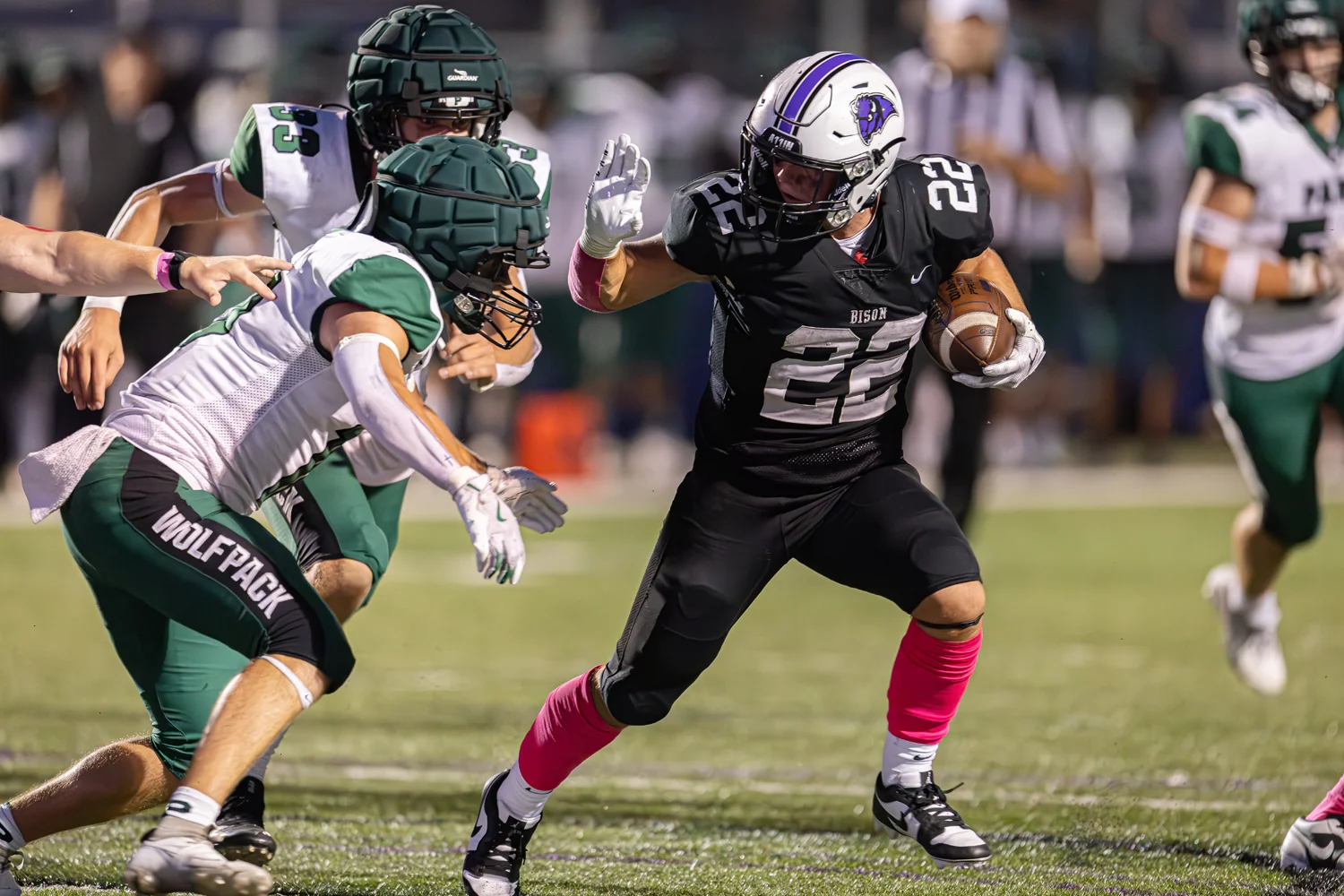 RB looking to avoid the defense with a stiff arm